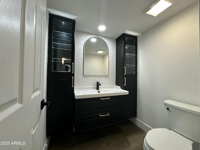 bathroom with toilet, hardwood / wood-style flooring, and vanity