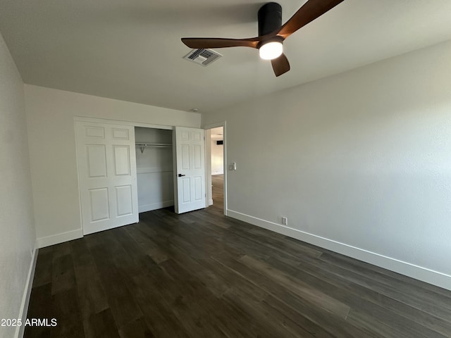 unfurnished bedroom with ceiling fan, dark wood-type flooring, and a closet