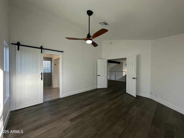 interior space with vaulted ceiling, ceiling fan, dark hardwood / wood-style flooring, and a barn door