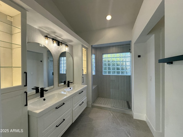 bathroom with lofted ceiling, vanity, and a tile shower