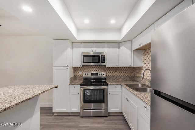 18202 Cave Creek Rd Unit 141, Phoenix, AZ 85032 - kitchen featuring stainless steel appliances, a sink, wood finished floors, backsplash, and white cabinets