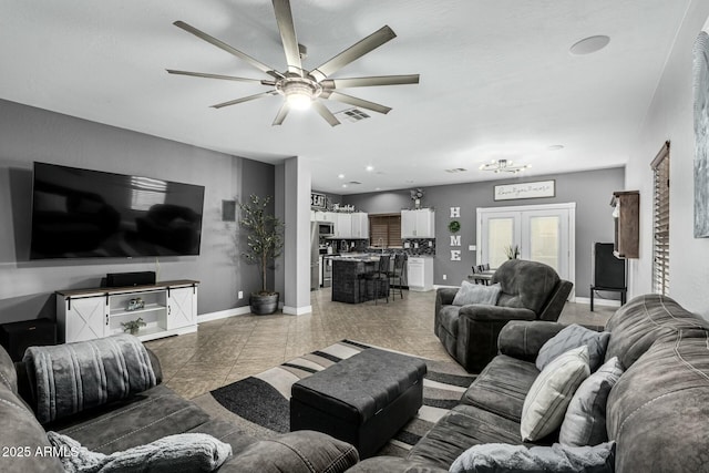 tiled living room with ceiling fan and french doors