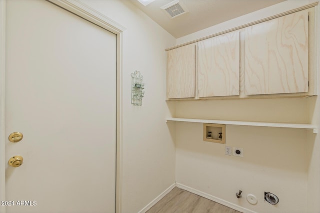 laundry room featuring cabinets, hookup for a washing machine, gas dryer hookup, electric dryer hookup, and light hardwood / wood-style floors