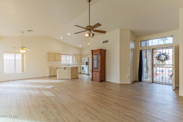 unfurnished living room featuring plenty of natural light, ceiling fan, and light hardwood / wood-style flooring