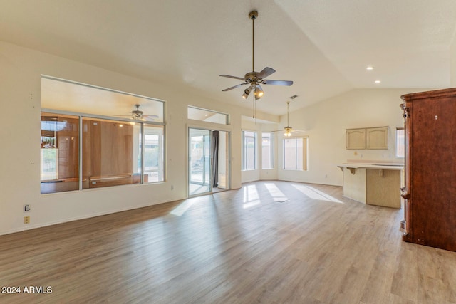 unfurnished living room featuring a healthy amount of sunlight, light wood-type flooring, and lofted ceiling