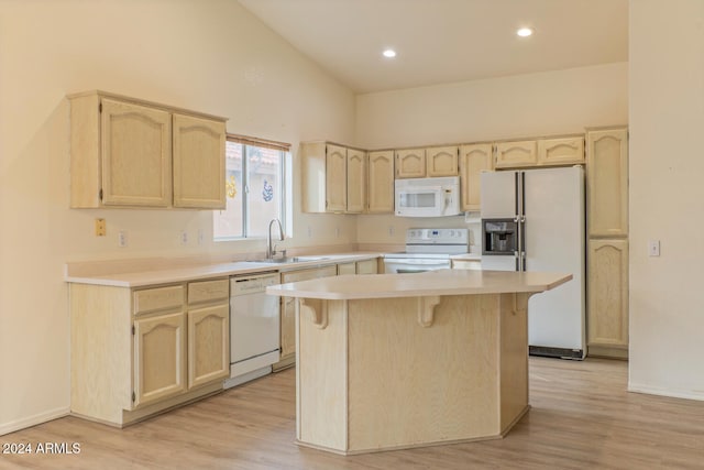 kitchen with sink, high vaulted ceiling, white appliances, a kitchen island, and light wood-type flooring