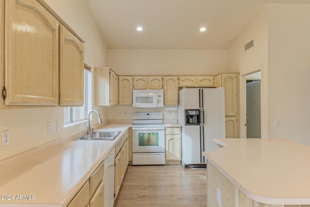 kitchen with light brown cabinetry, white appliances, vaulted ceiling, sink, and light hardwood / wood-style floors