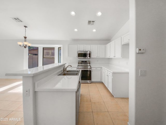 kitchen with appliances with stainless steel finishes, decorative light fixtures, an island with sink, sink, and white cabinets