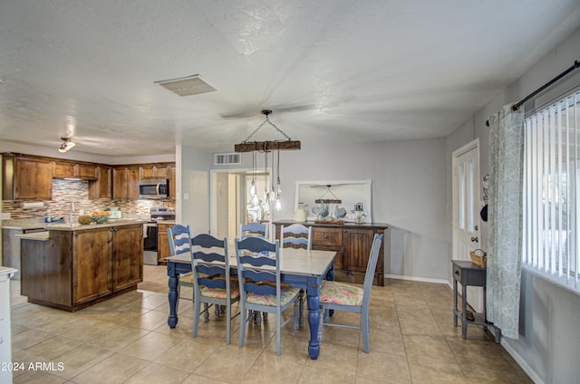 dining room with a textured ceiling and light tile patterned flooring