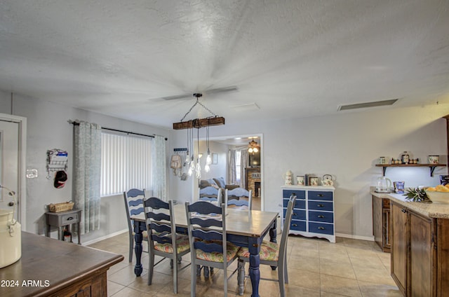 tiled dining space featuring ceiling fan and a textured ceiling