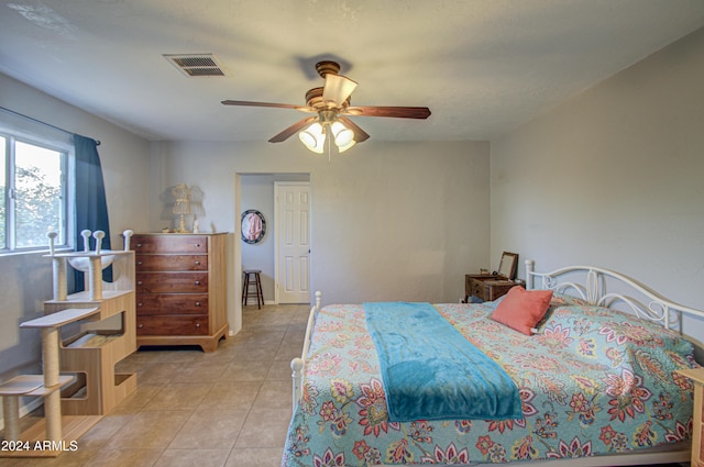 tiled bedroom featuring ceiling fan