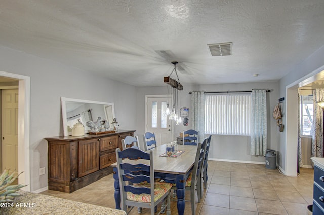 tiled dining space with a textured ceiling