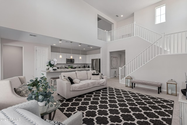 living room with light carpet and a towering ceiling