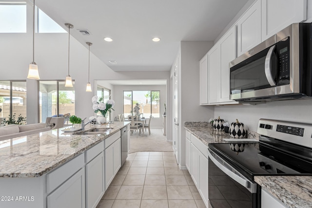 kitchen with white cabinets, appliances with stainless steel finishes, sink, and light tile patterned floors