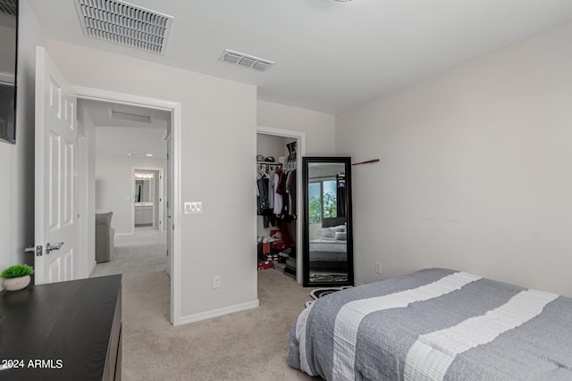 carpeted bedroom with a closet and a walk in closet