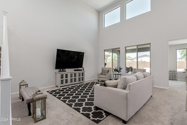 carpeted living room featuring a towering ceiling