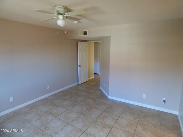 empty room with light tile patterned flooring and ceiling fan