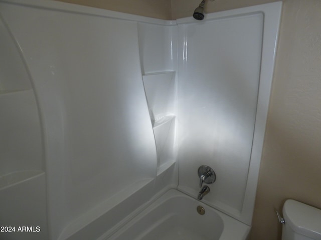 bathroom with washtub / shower combination and toilet