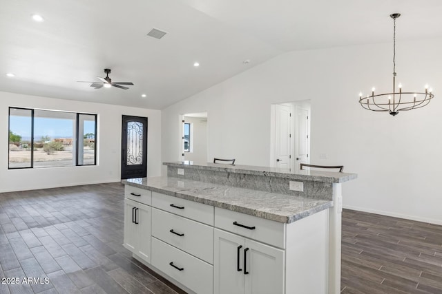 20111 W Saguaro Vista Dr, Wittmann, AZ 85361 - kitchen featuring visible vents, ceiling fan with notable chandelier, open floor plan, dark wood-type flooring, and vaulted ceiling