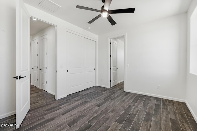 20111 W Saguaro Vista Dr, Wittmann, AZ 85361 - unfurnished bedroom featuring baseboards, visible vents, dark wood-style floors, and a closet