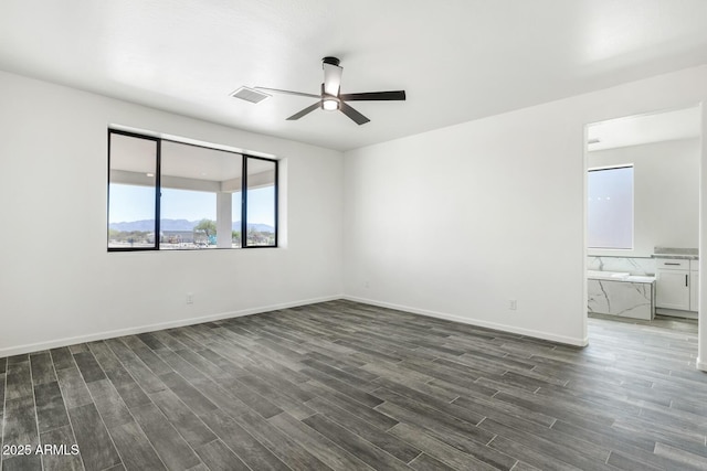 20111 W Saguaro Vista Dr, Wittmann, AZ 85361 - empty room featuring visible vents, dark wood-style flooring, ceiling fan, and baseboards