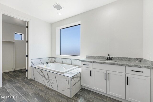 20111 W Saguaro Vista Dr, Wittmann, AZ 85361 - bathroom featuring visible vents, wood tiled floor, a garden tub, and vanity