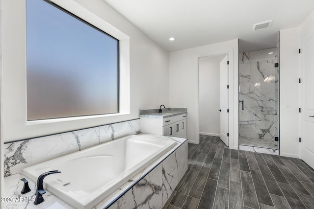 20111 W Saguaro Vista Dr, Wittmann, AZ 85361 - bathroom featuring visible vents, baseboards, recessed lighting, a bath, and a marble finish shower