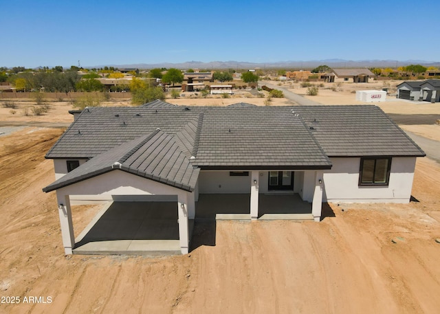 20111 W Saguaro Vista Dr, Wittmann, AZ 85361 - rear view of property with a mountain view, stucco siding, an attached garage, and driveway