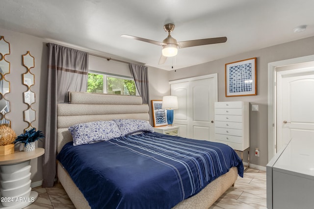 bedroom with light tile patterned floors, a closet, and ceiling fan