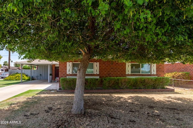 view of property hidden behind natural elements with a carport