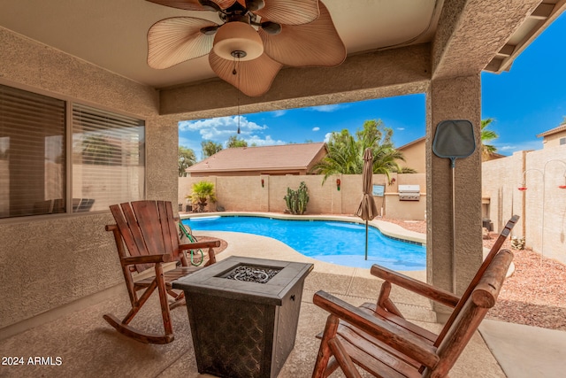 view of pool with ceiling fan, a patio area, and a fire pit