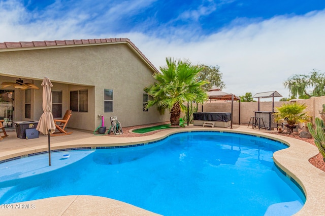 view of swimming pool with ceiling fan and a patio area