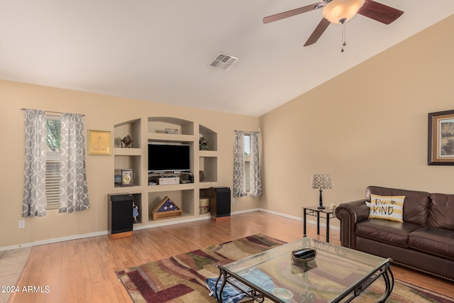 living room featuring lofted ceiling, built in shelves, ceiling fan, and light hardwood / wood-style floors