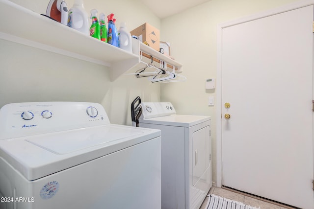 laundry area with light tile patterned floors and washer and clothes dryer