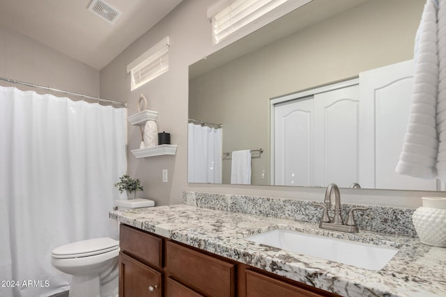 bathroom with vanity, toilet, and vaulted ceiling