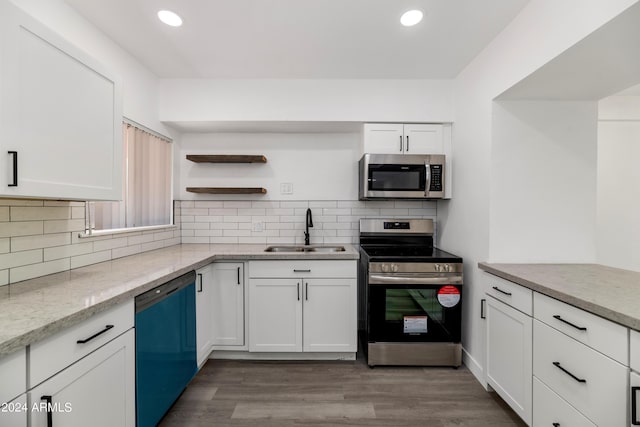 kitchen featuring white cabinets, light stone counters, sink, and appliances with stainless steel finishes