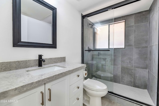 bathroom featuring walk in shower, vanity, and toilet