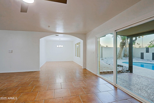3054 W Redfield Rd, Phoenix, AZ 85053 - spare room featuring arched walkways, baseboards, and a chandelier