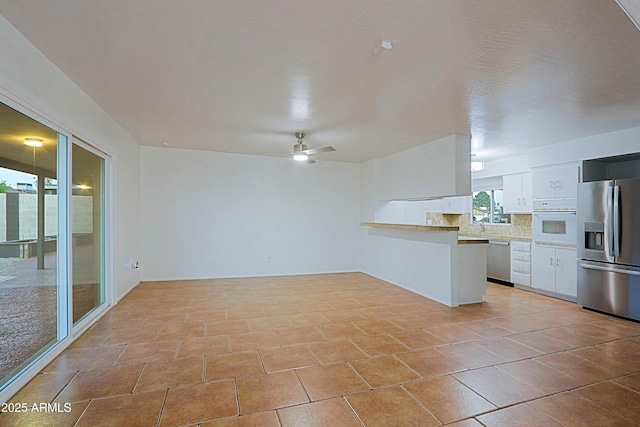 3054 W Redfield Rd, Phoenix, AZ 85053 - kitchen with appliances with stainless steel finishes, white cabinets, a ceiling fan, backsplash, and light countertops