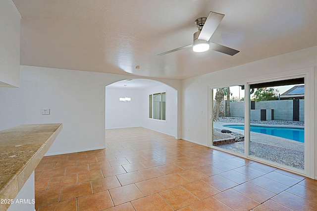 3054 W Redfield Rd, Phoenix, AZ 85053 - empty room with ceiling fan, baseboards, arched walkways, and a chandelier