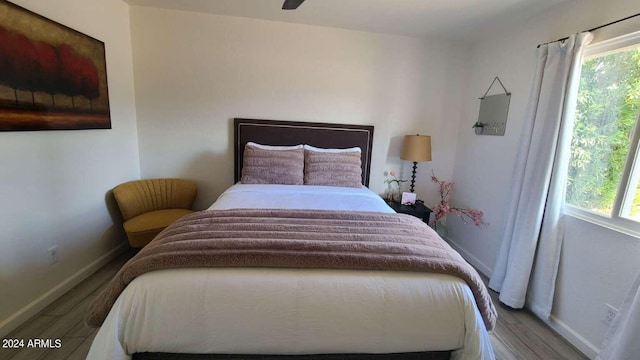 bedroom with hardwood / wood-style flooring and multiple windows