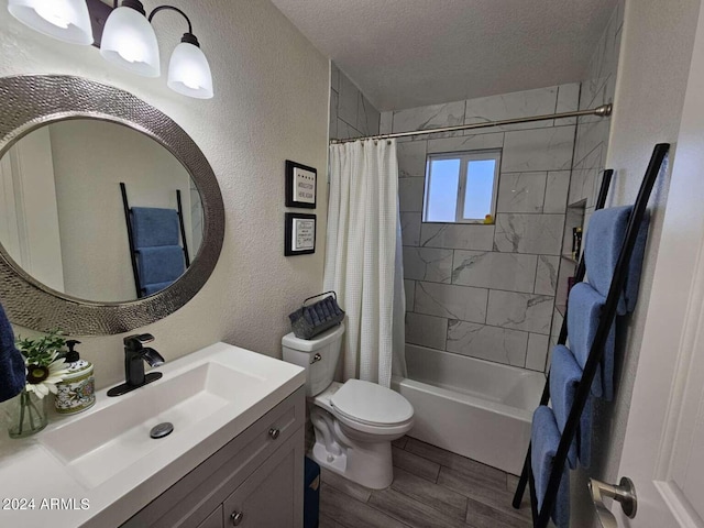 full bathroom with hardwood / wood-style floors, vanity, toilet, shower / bathtub combination with curtain, and a textured ceiling