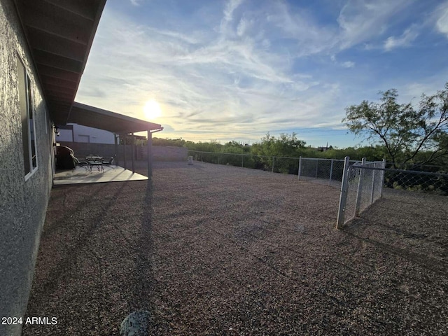 yard at dusk featuring a patio area