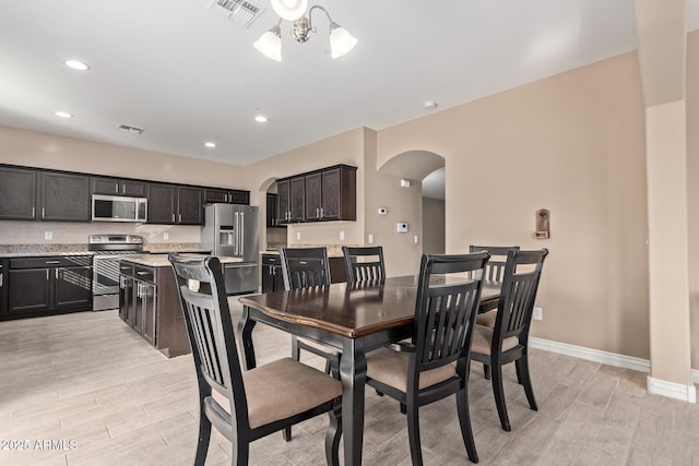 dining space featuring light hardwood / wood-style floors and a notable chandelier