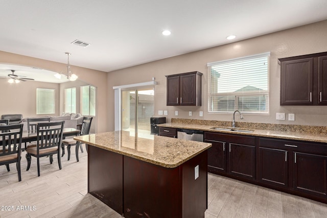 kitchen with dishwasher, sink, hanging light fixtures, dark brown cabinets, and a kitchen island