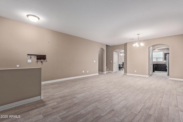 unfurnished living room featuring light hardwood / wood-style floors and a notable chandelier