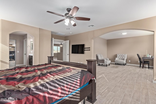 bedroom with light wood-type flooring, ensuite bathroom, and ceiling fan