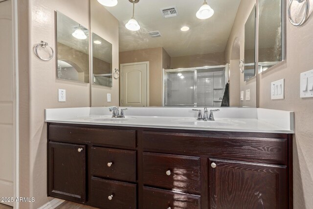 bathroom featuring vanity and a shower with shower door