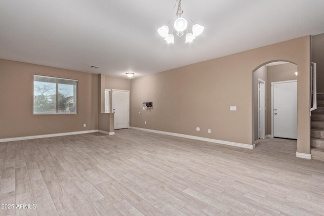 unfurnished room featuring light hardwood / wood-style flooring and an inviting chandelier