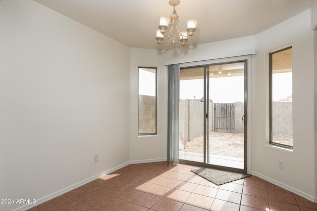 doorway to outside featuring plenty of natural light, a chandelier, and tile patterned flooring